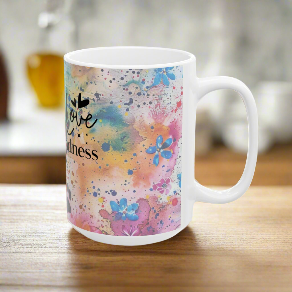White mug with colorful abstract Love Like Nalah  design and 'love kindness' text on a wooden surface.
