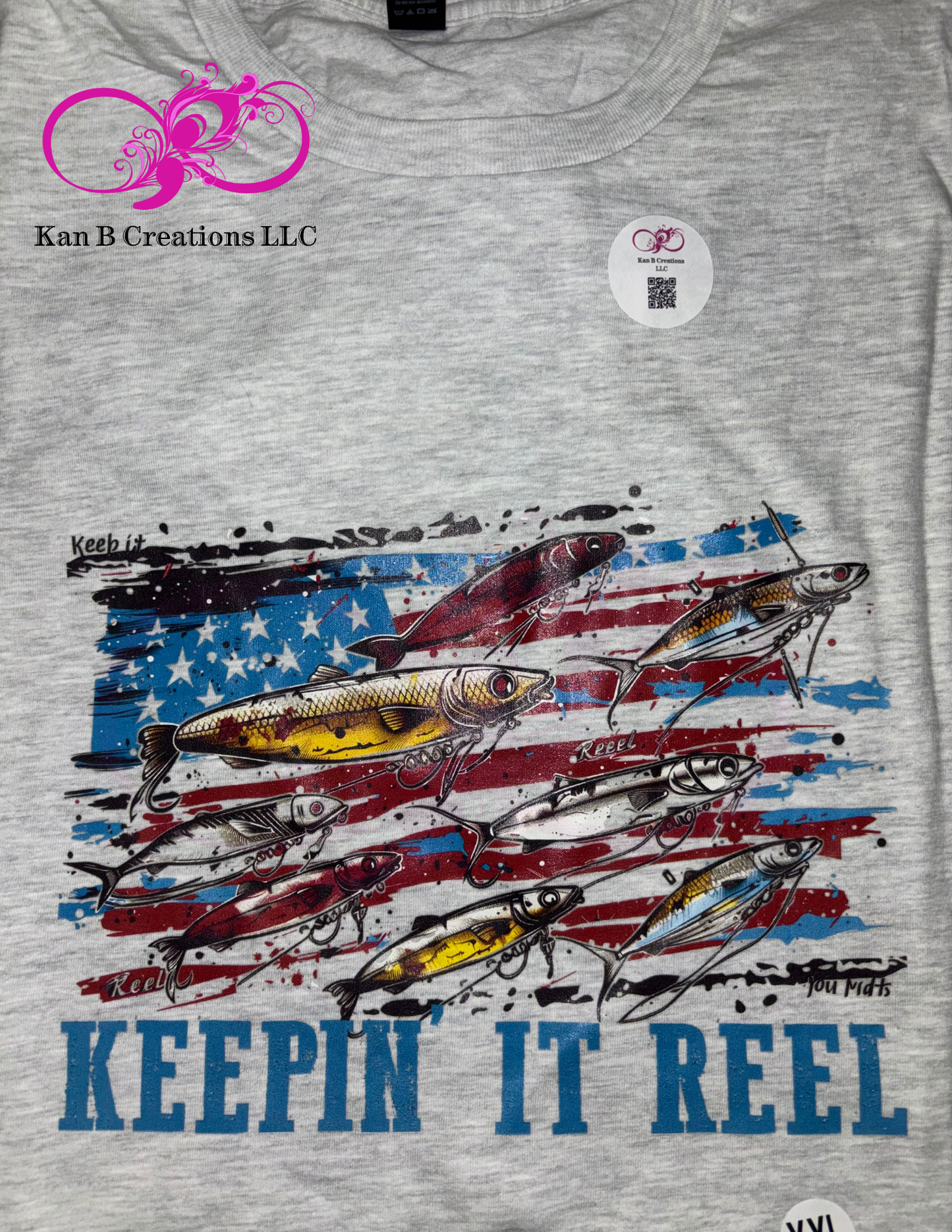 Gray t-shirt with fishing lure design and 'Keepin' It Reel' text on an American flag background. 